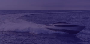 Barca a motore che naviga rapidamente sull'acqua con onde in movimento.
